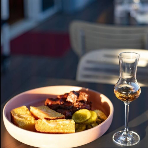 glass of whiskey and barbecue plate